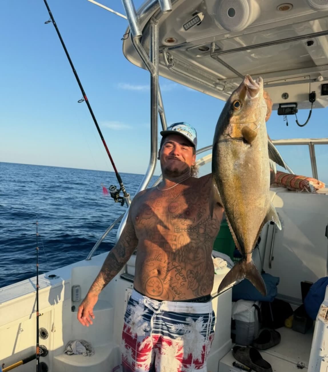Capt. Travis Trotter's crew hoisting a greater amberjack under the hardtop